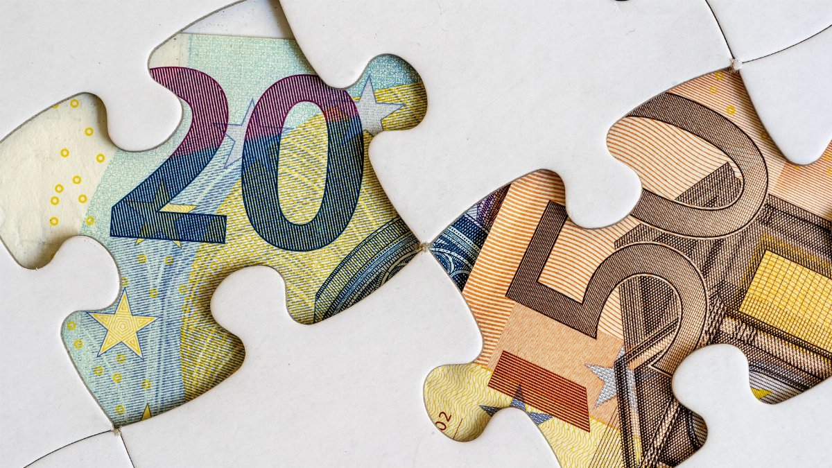 Euro banknotes creatively displayed within a jigsaw puzzle theme.