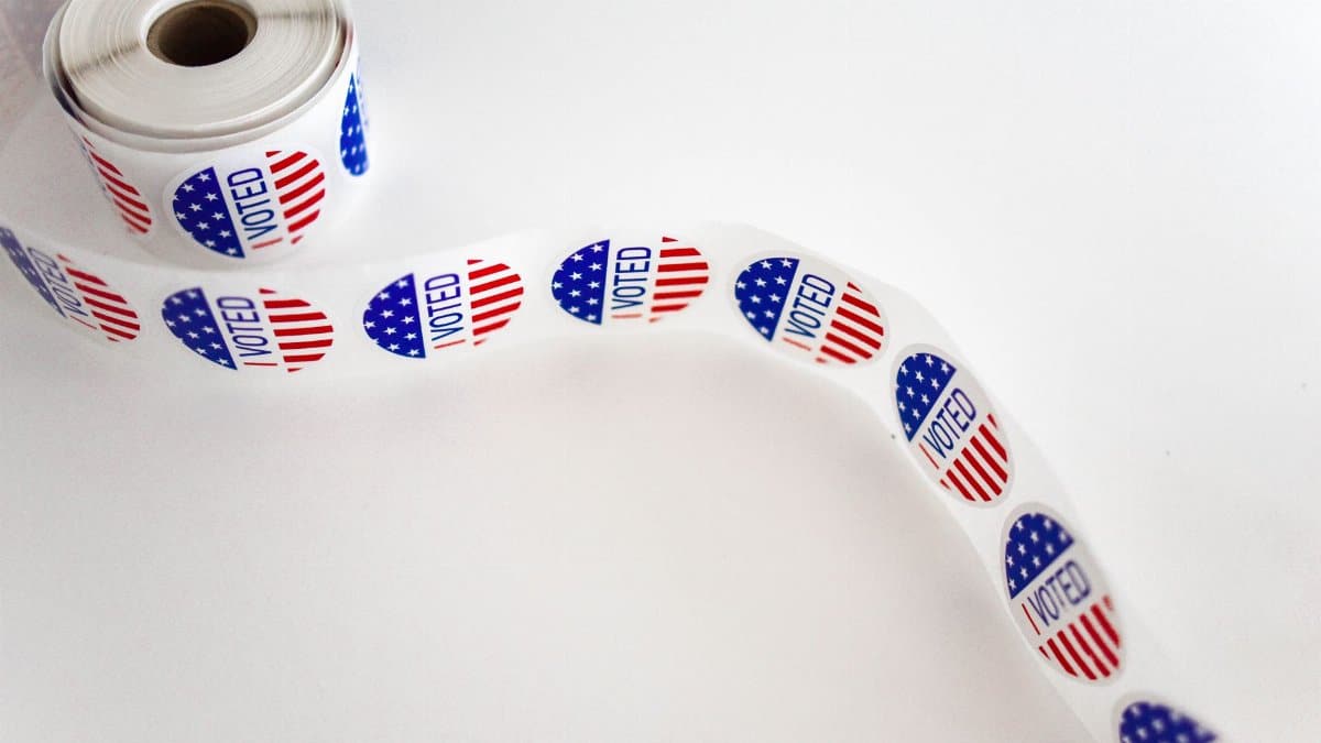 Close-up of a roll of 'I Voted' stickers featuring the American flag design on a white background.