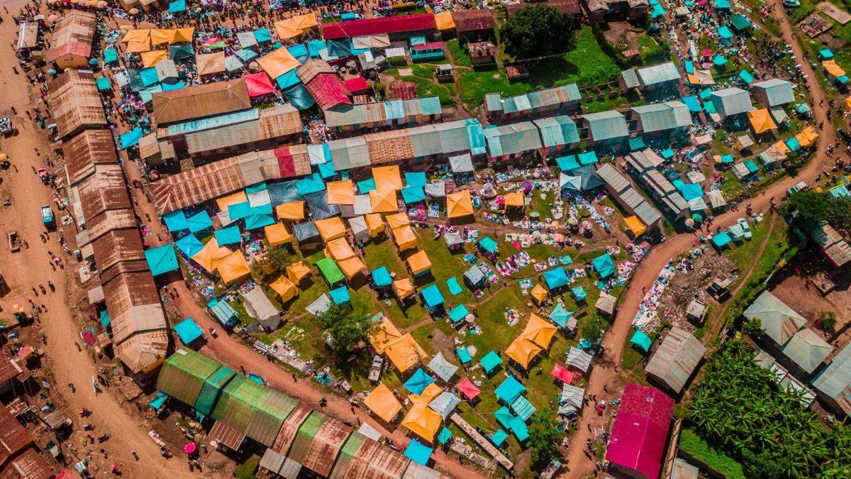 Vibrant aerial shot of a bustling market in Uganda, showcasing colorful stalls and roofs.