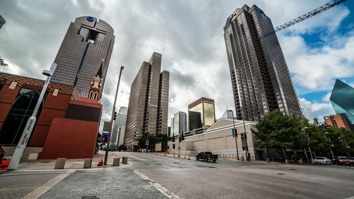 Explore the modern skyline of downtown Dallas, Texas with towering skyscrapers under a dramatic sky.
