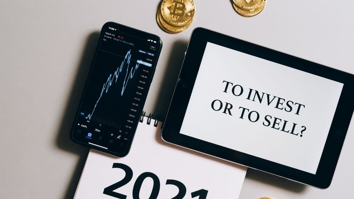 Overhead view of tablet, smartphone with chart, Bitcoin coins symbolizing investment choices for 2021.