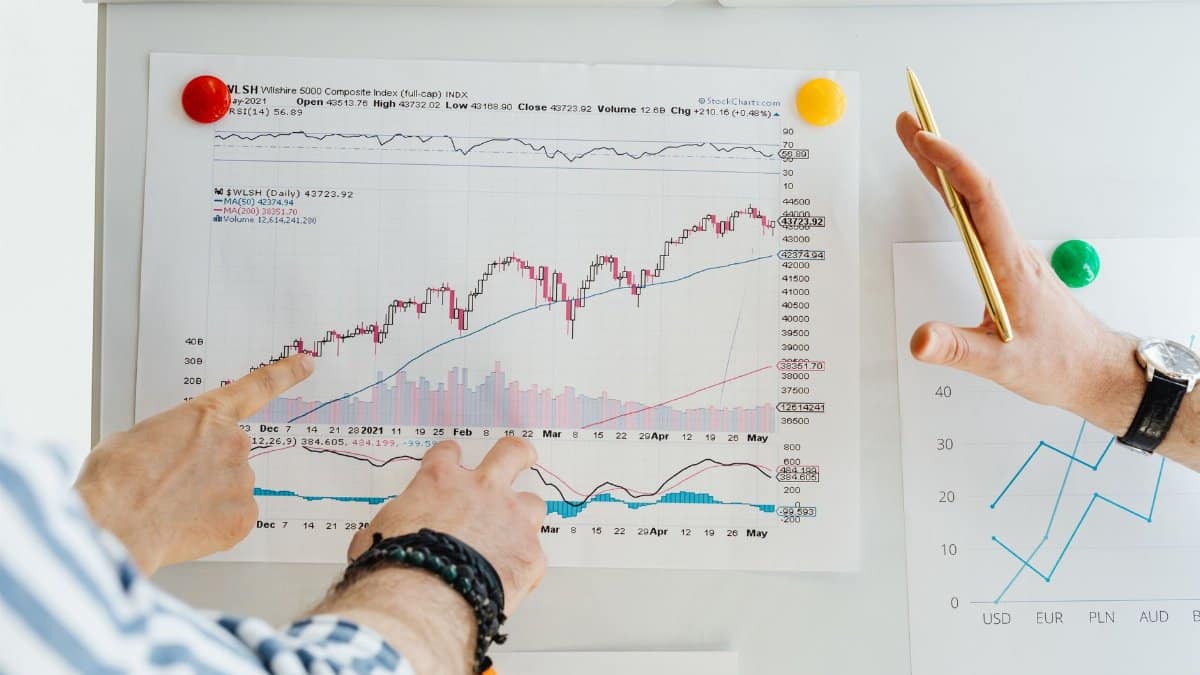Two professionals analyze stock market graphs with a focus on finance and data trends.