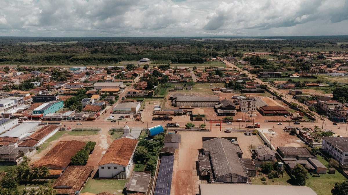 Aerial view capturing a blend of residential and commercial buildings under a cloudy sky in a rural town.