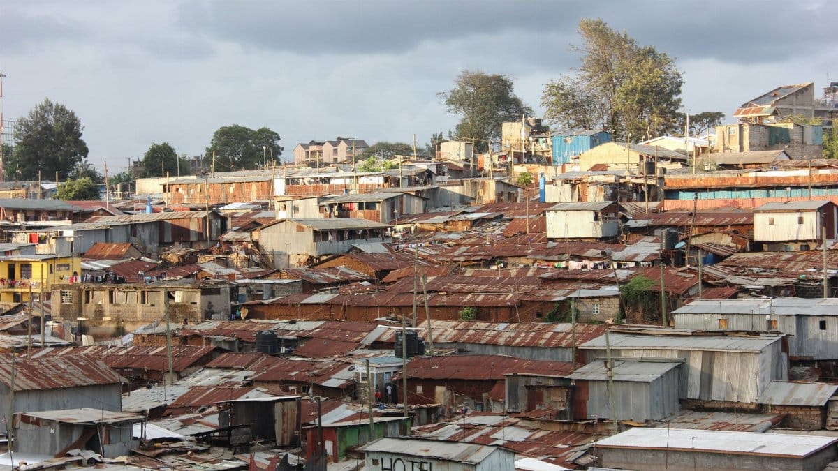 Aerial shot of sprawling slum areas and corrugated rooftops in Nairobi, Kenya.