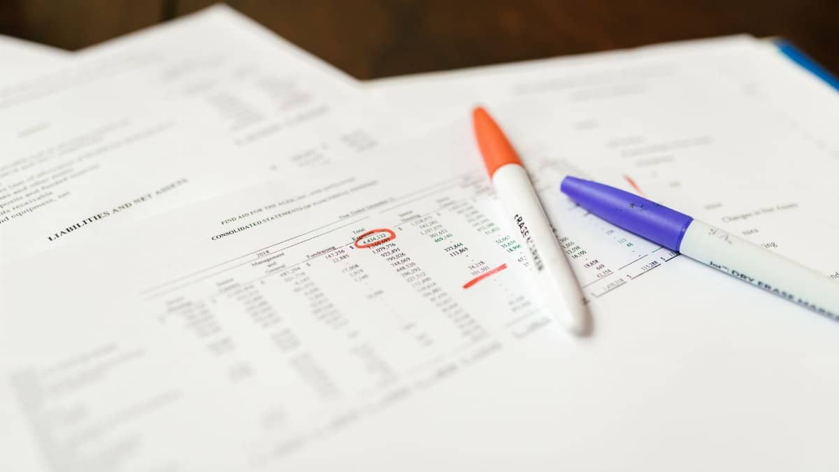 Close-up of financial documents with pens highlighting important data points.