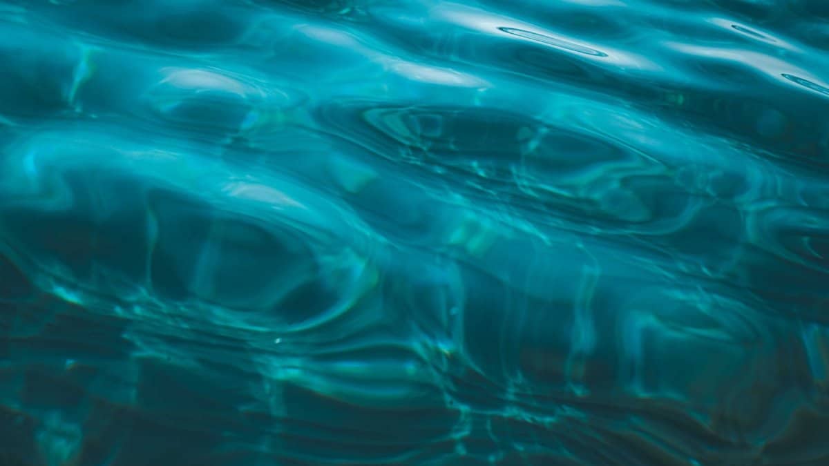 Overhead view of abstract background representing transparent sea aqua with ripples on shiny surface