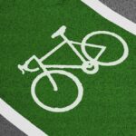 Bright green bicycle lane with white bike symbol and clear road texture.