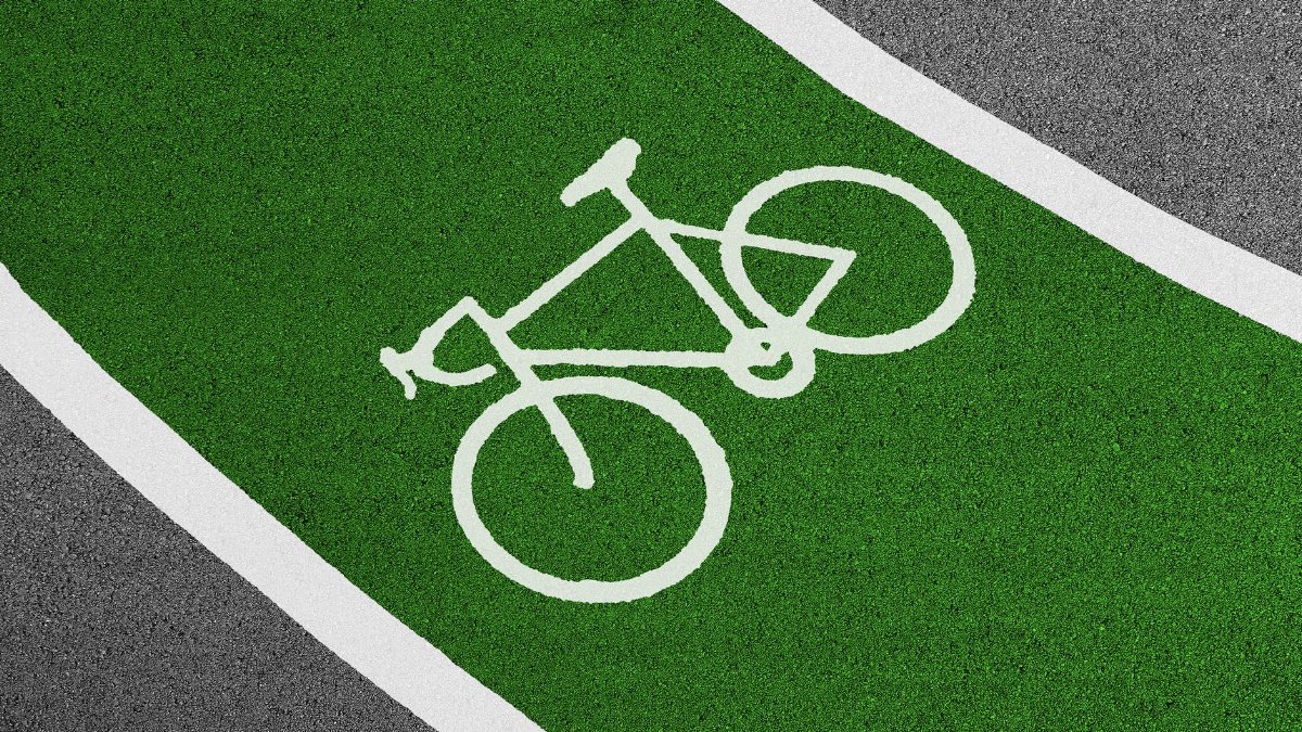 Bright green bicycle lane with white bike symbol and clear road texture.