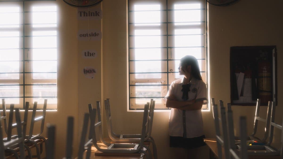 A thoughtful student looks out the window in a sunlit classroom in Lạng Sơn, Vietnam.