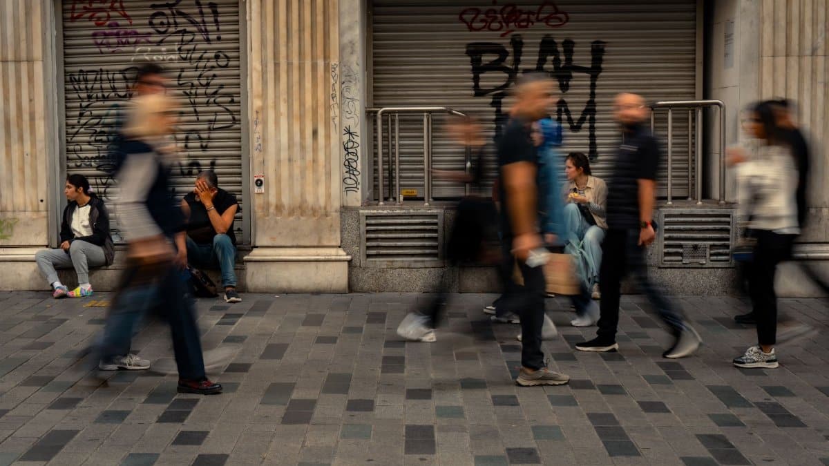 Street scene with people in motion blur, depicting urban life and public space dynamics.