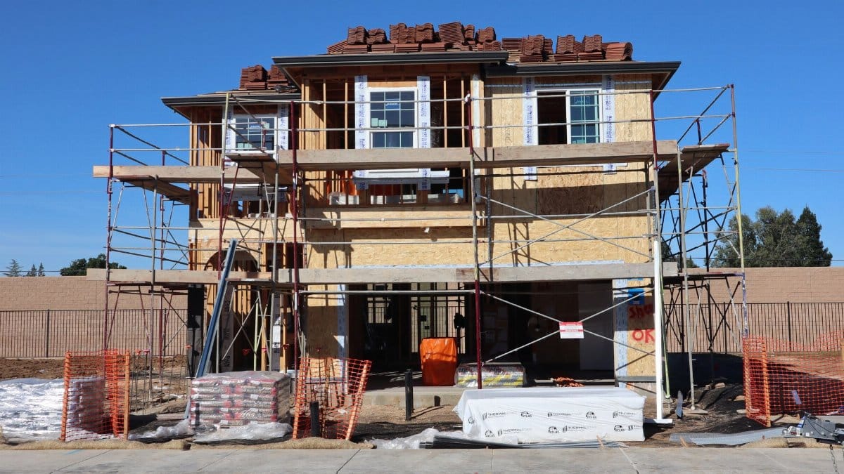 Construction underway for a new home in Elk Grove, California. Scaffolding and materials onsite.