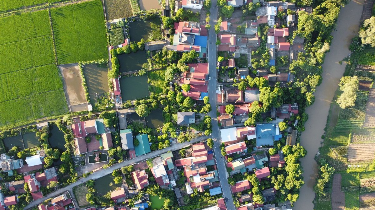 Stunning aerial view of Vietnamese rural area with lush fields and traditional houses.