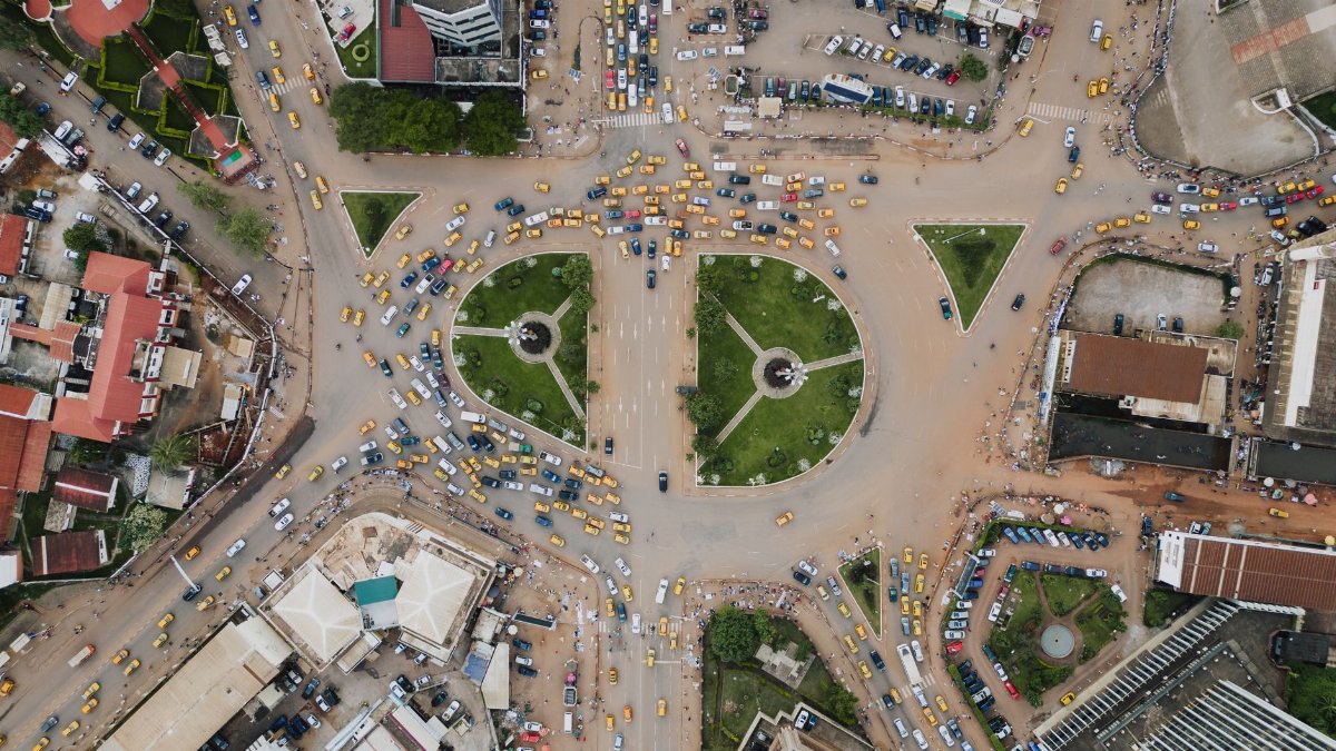 A bustling traffic circle in Yaoundé, Cameroon, captured from above showing lively city life.
