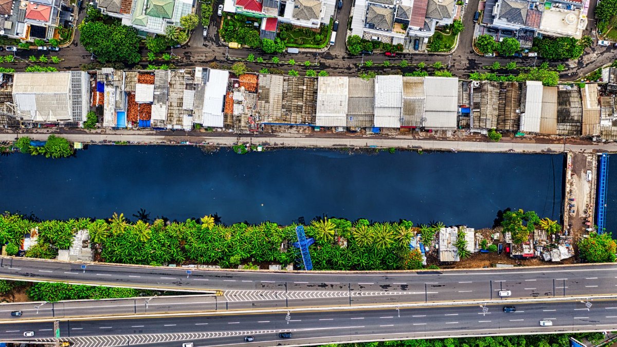 Aerial shot showcasing Jakarta's vibrant neighborhood, river, and highway.