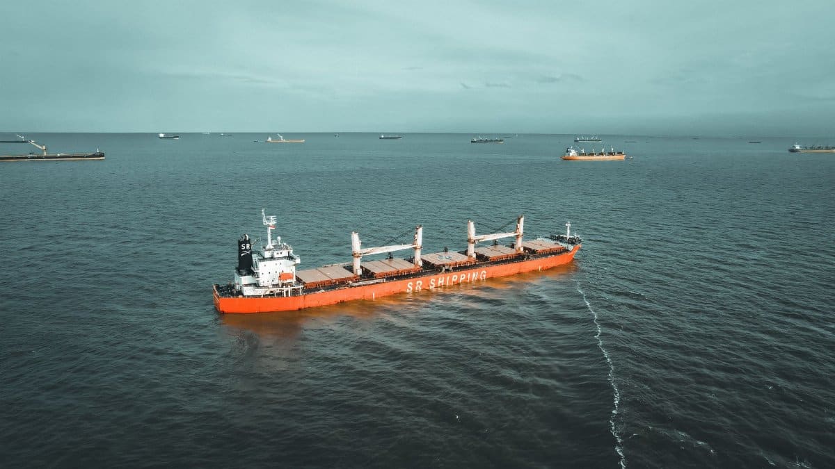 Drone view of a cargo ship navigating the ocean, showcasing maritime transport.