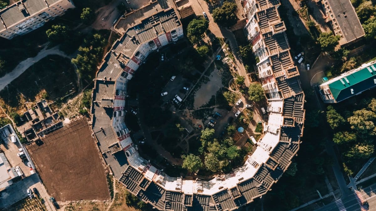 Overhead view of a circular urban residential area with surrounding greenery.