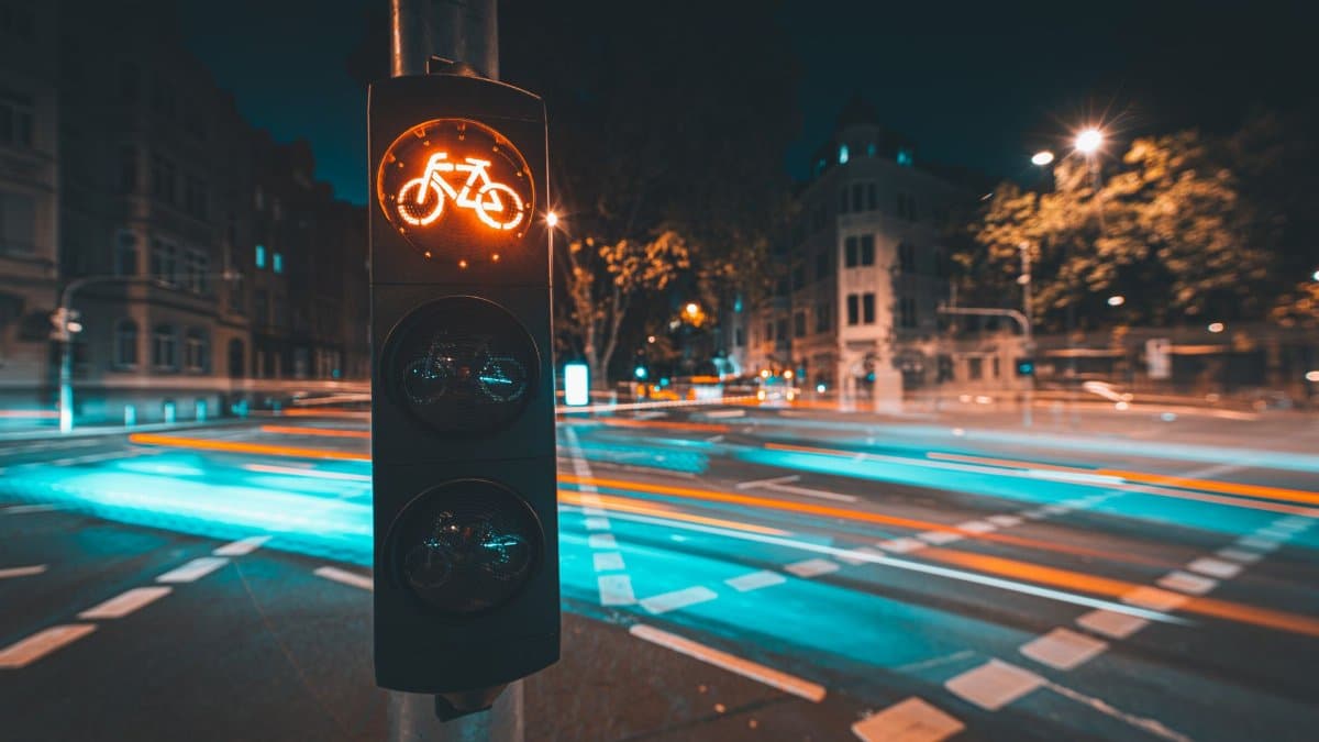 Bicycle traffic light with light trails in Wiesbaden at night, showcasing urban life and motion.