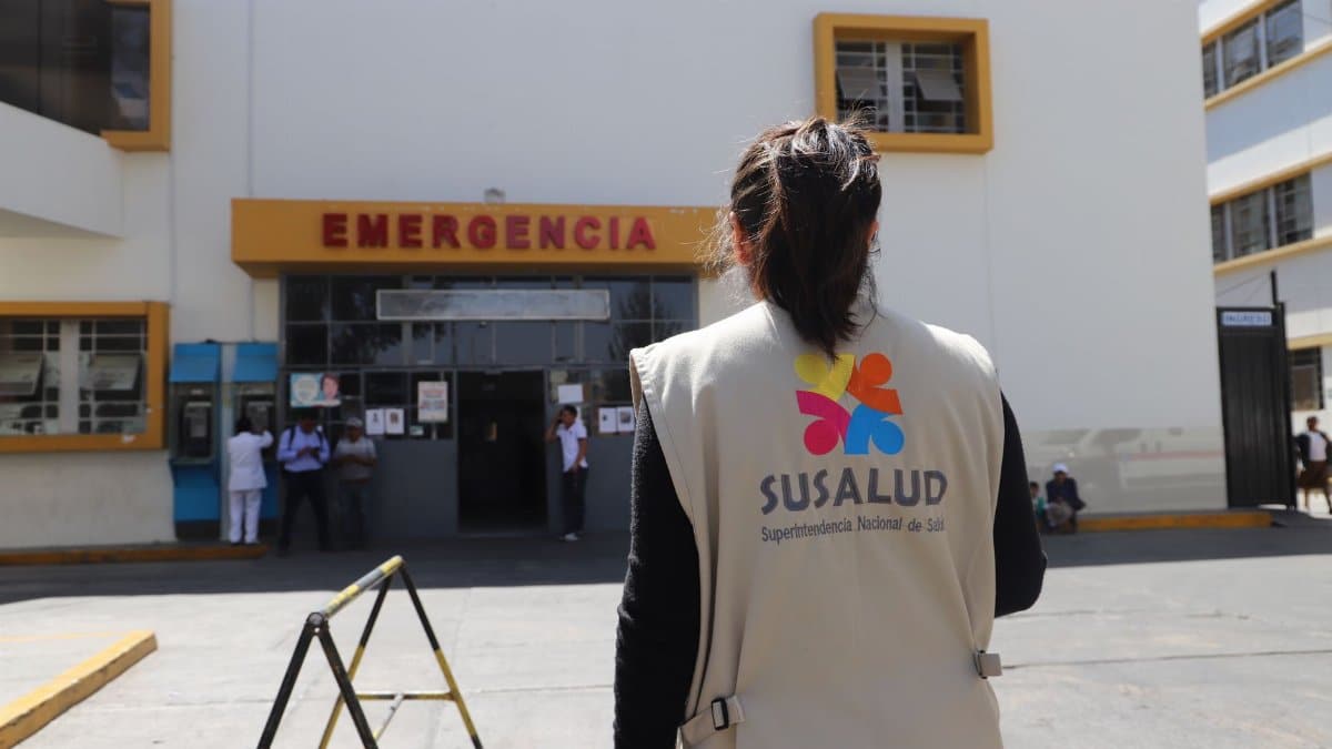 A SUSALUD official outside an emergency entrance at a hospital during the day.
