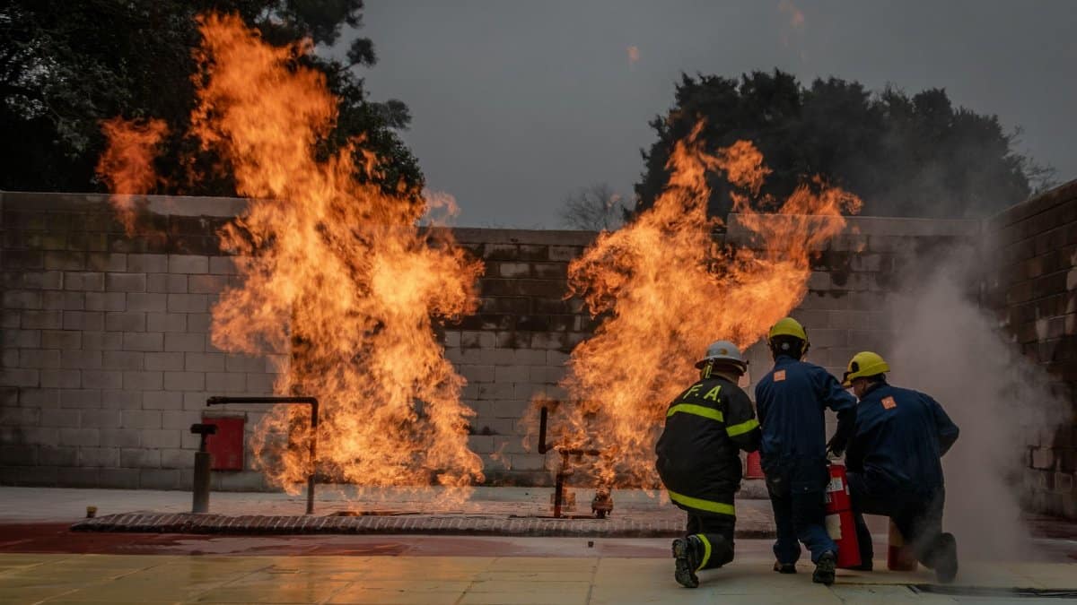 Firefighters in action suppressing a controlled blaze. Dramatic firefighting training scenario.