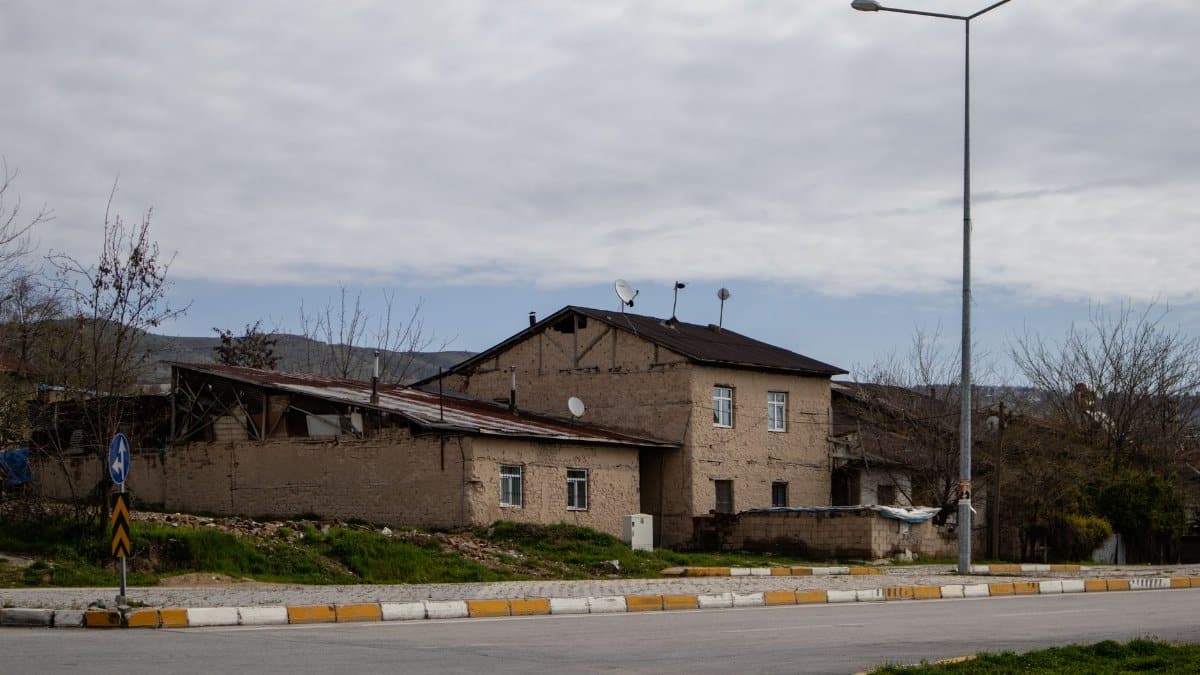 A quiet street with old buildings in Elâzığ, Türkiye. Captured on a cloudy day, showcasing rustic architecture.