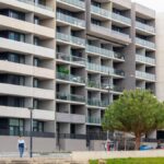 Spacious urban apartment building featuring multiple balconies and a modern architectural design.