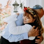 A heartfelt embrace between family members celebrating a Jewish holiday outdoors.