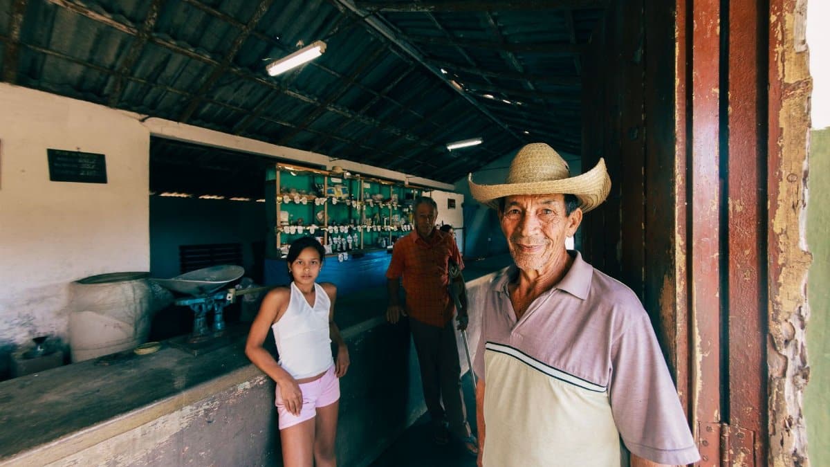 Three individuals in a rustic market setting, capturing the essence of local commerce and community.