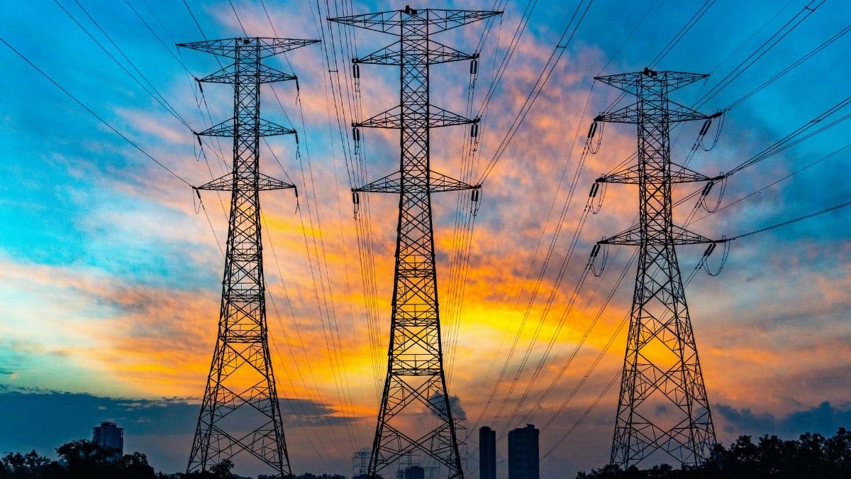 High voltage power lines against a dramatic sunset sky, symbolizing energy and technology.