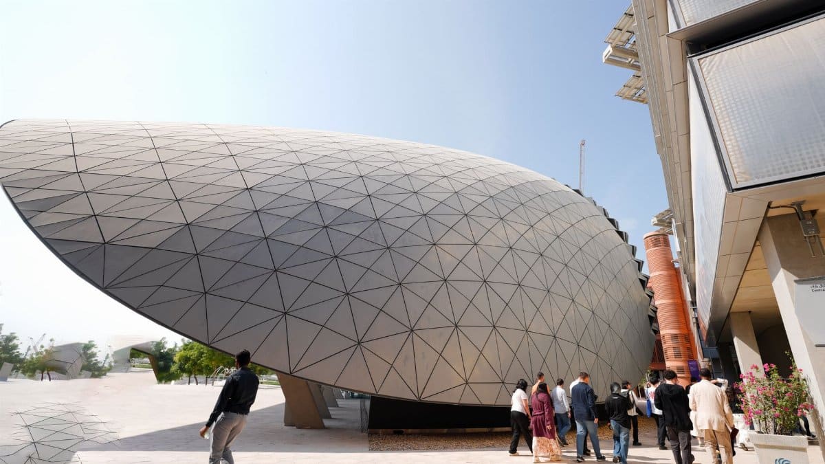 A modern dome structure with geometric patterns surrounded by visitors outdoors