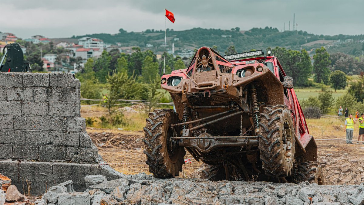 A red offroad vehicle navigates a rocky terrain, showcasing its strength and durability during an outdoor race.