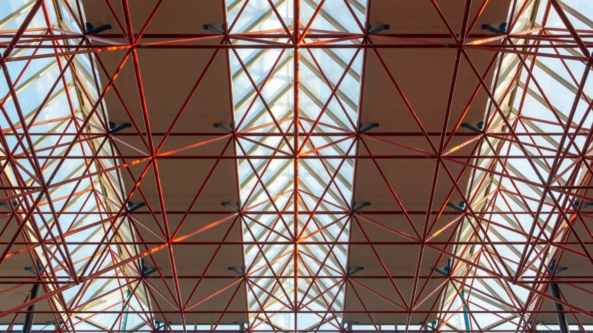 An intricate geometric ceiling structure with metal framework and glass panels.