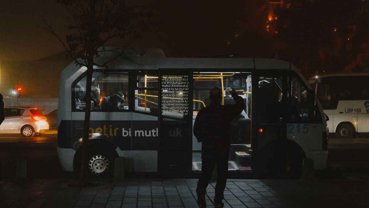 Silhouette of a person entering a bus at night in Istanbul's public transportation system.