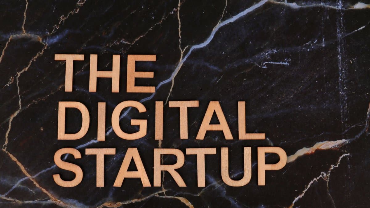 Wooden letters spelling 'The Digital Startup' on a dark marble background. Ideal for business and tech themes.