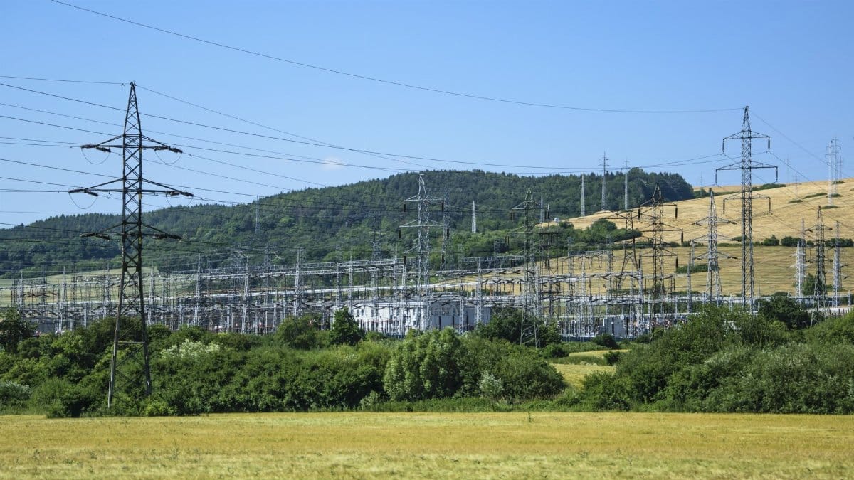 Electric transmission towers against a rural landscape, showcasing energy infrastructure.
