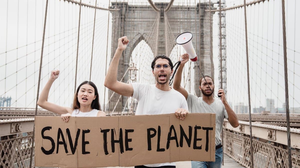 Protesters with banners and megaphones demanding environmental action on Brooklyn Bridge, New York.