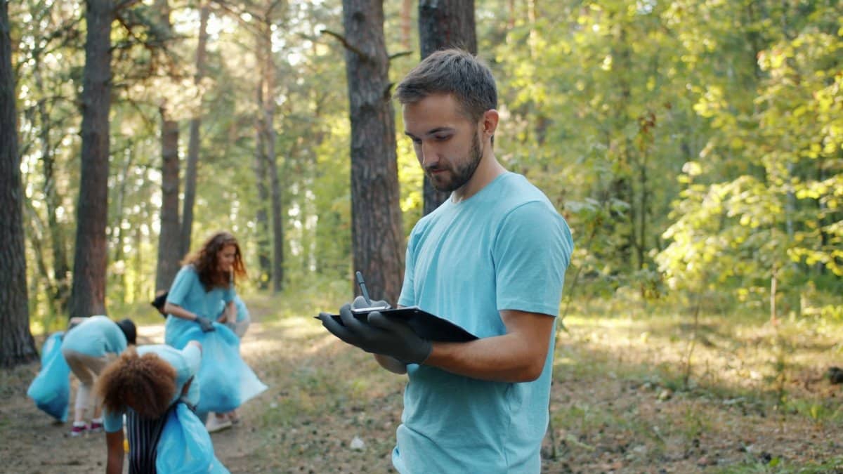 Volunteers picking up litter in a forest, promoting environmental conservation.