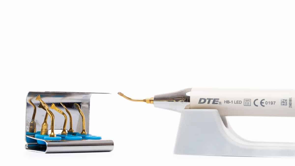 Close up of a dental ultrasonic scaler tool with multiple insert tips for dental hygiene.