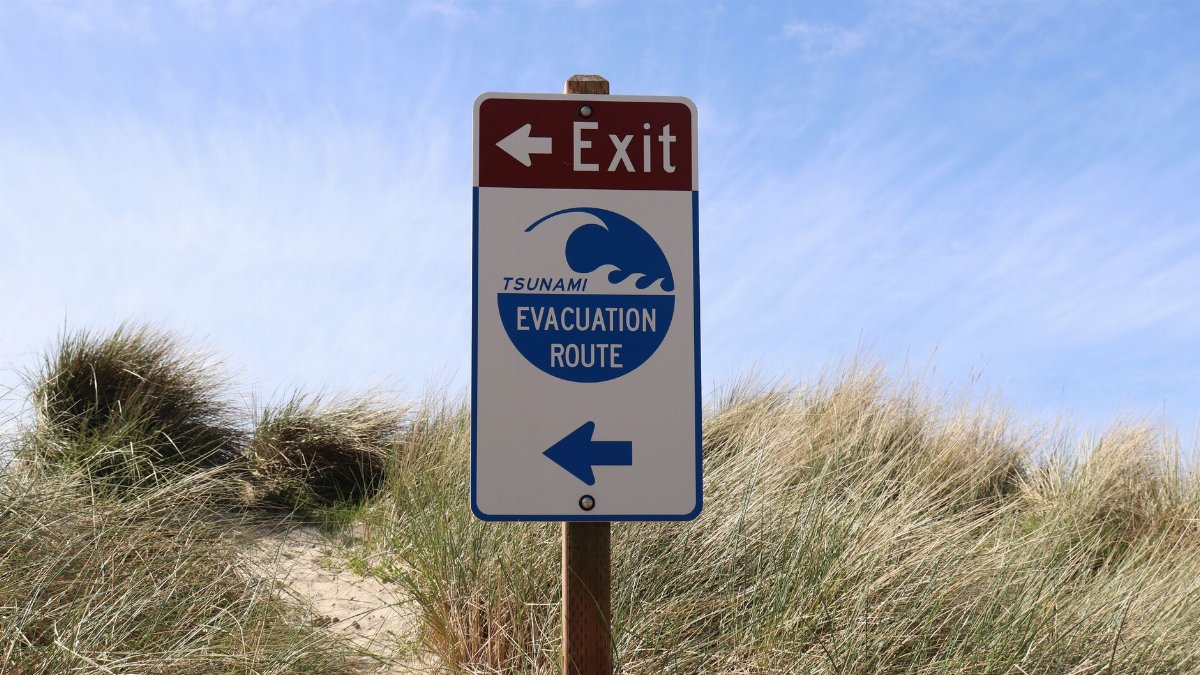 Tsunami evacuation route sign at Cannon Beach, Oregon, guiding beachgoers to safety.