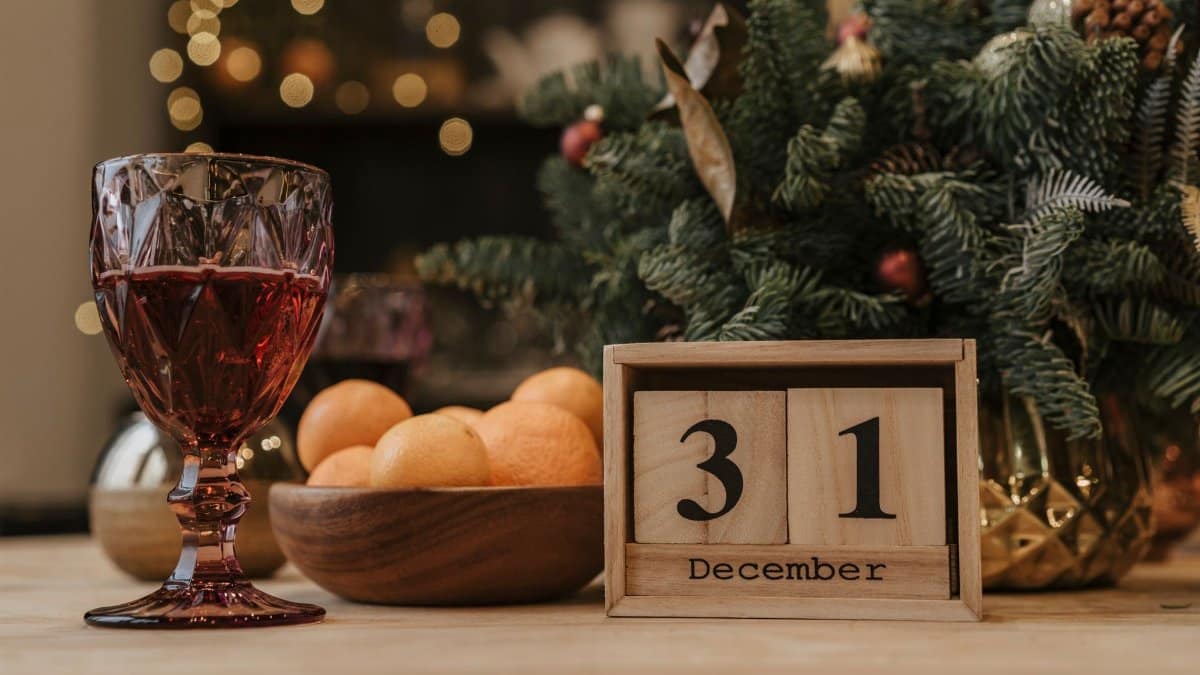 Festive New Year's Eve scene with a glass of red wine, December 31 calendar, and holiday decor.