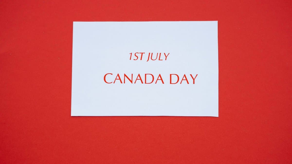 A white card with red text displaying '1st July Canada Day' on a red background.