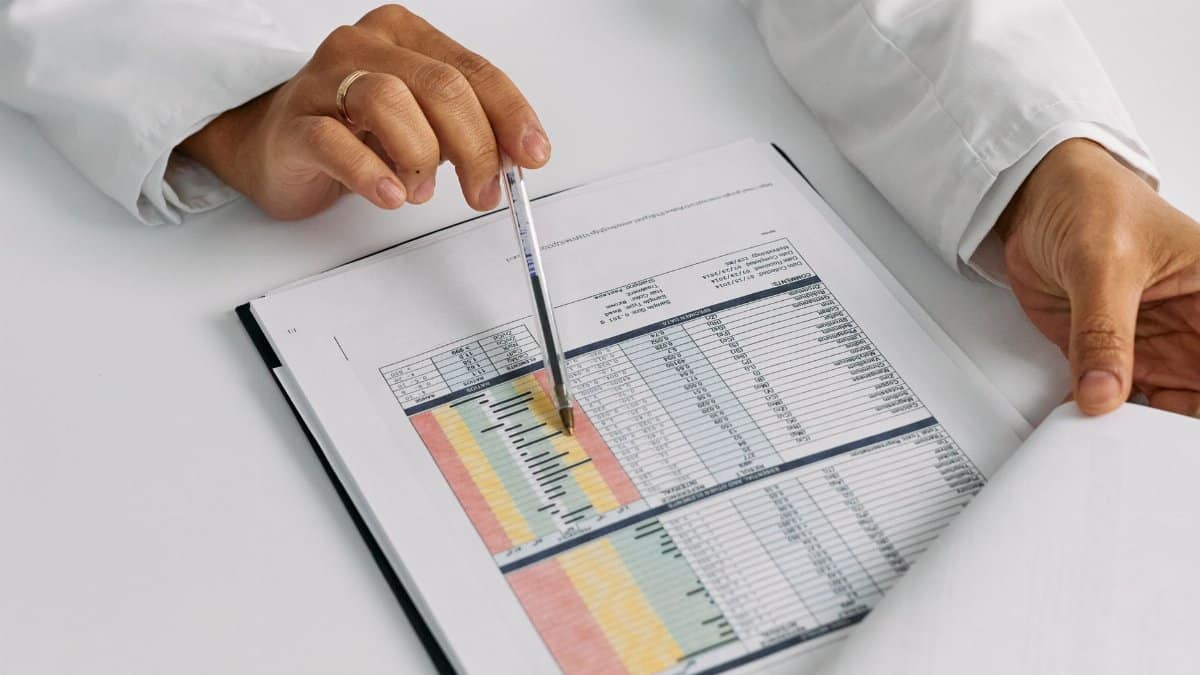 Doctor hands examining and pointing at medical charts in a close-up view.