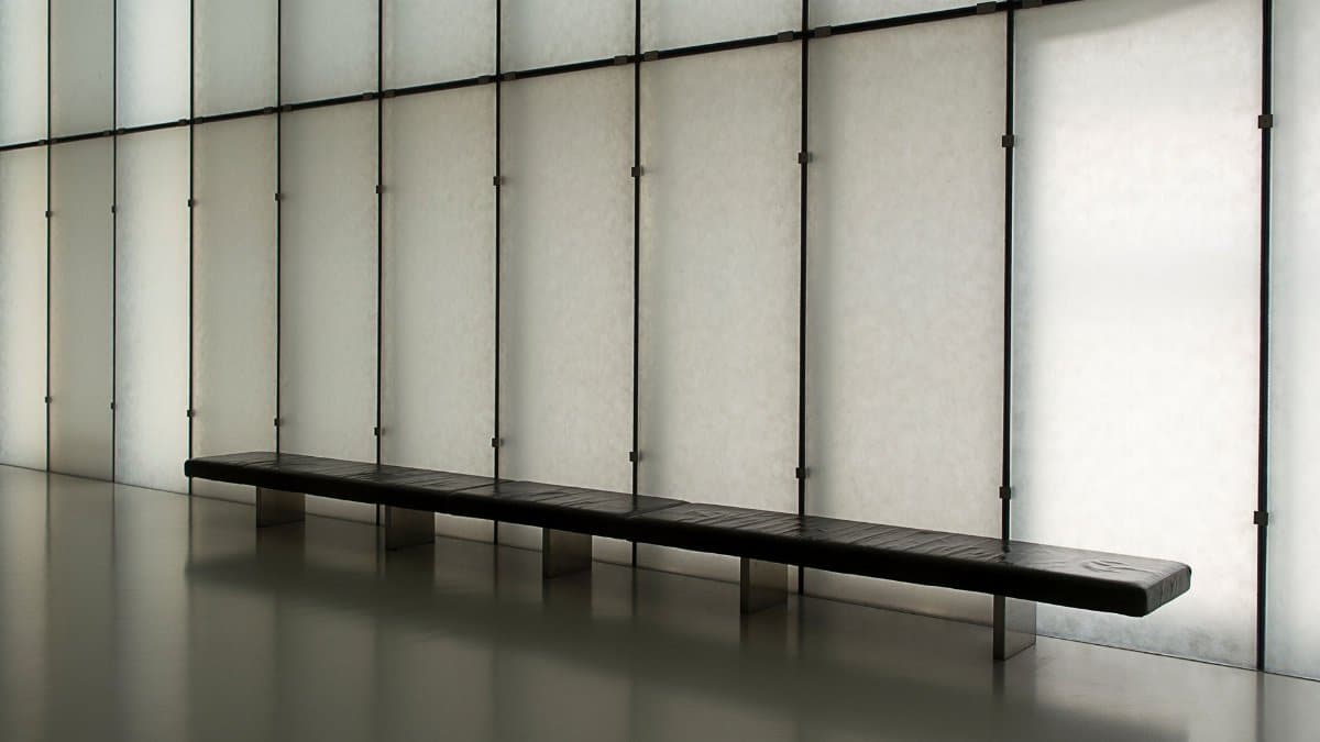 A modern minimalist interior featuring a long black bench against panel walls. Ideal for design concepts.