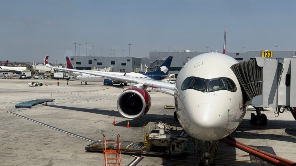 A large passenger airplane docked at a terminal at LAX, ready for boarding on a sunny day.