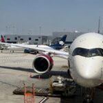 A large passenger airplane docked at a terminal at LAX, ready for boarding on a sunny day.