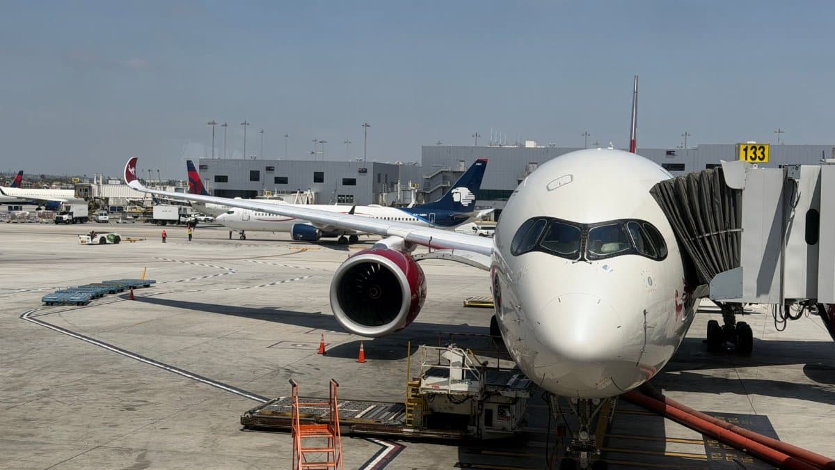 A large passenger airplane docked at a terminal at LAX, ready for boarding on a sunny day.