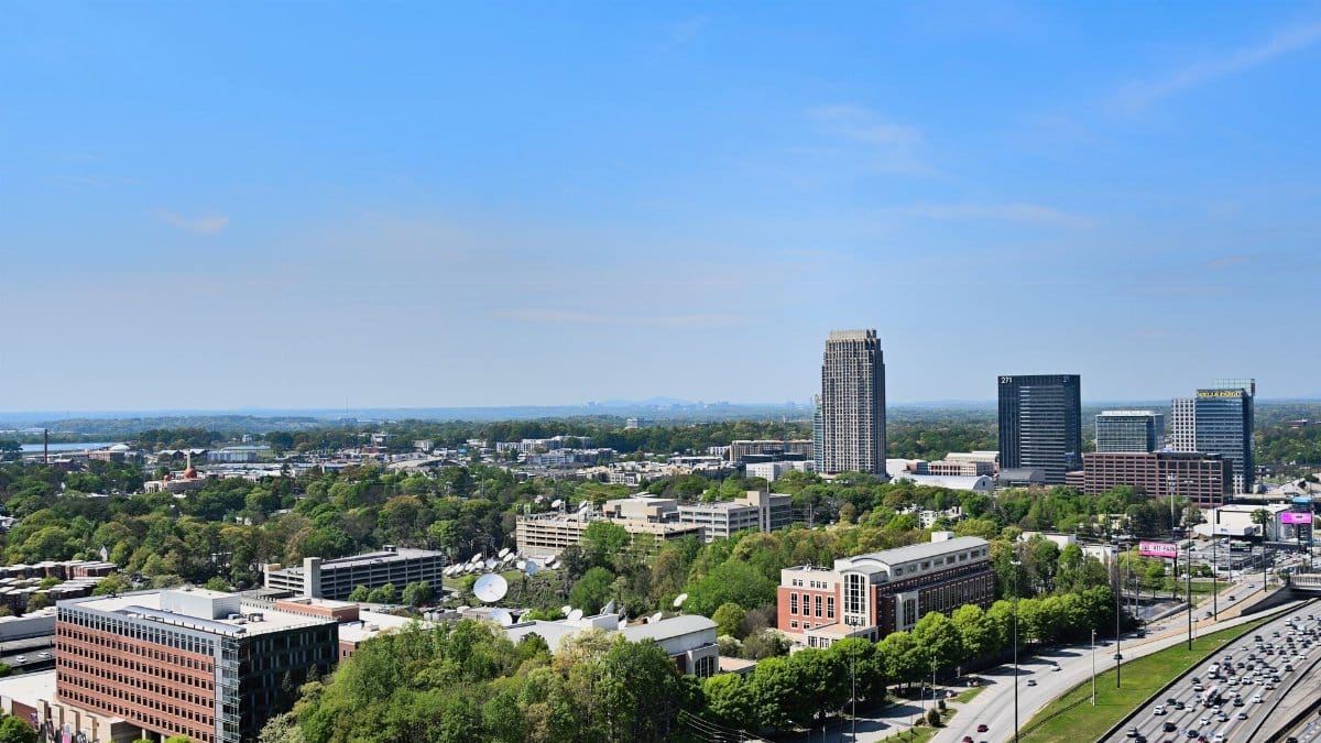 Vibrant aerial cityscape of Atlanta, Georgia showcases the urban skyline under a clear blue sky.