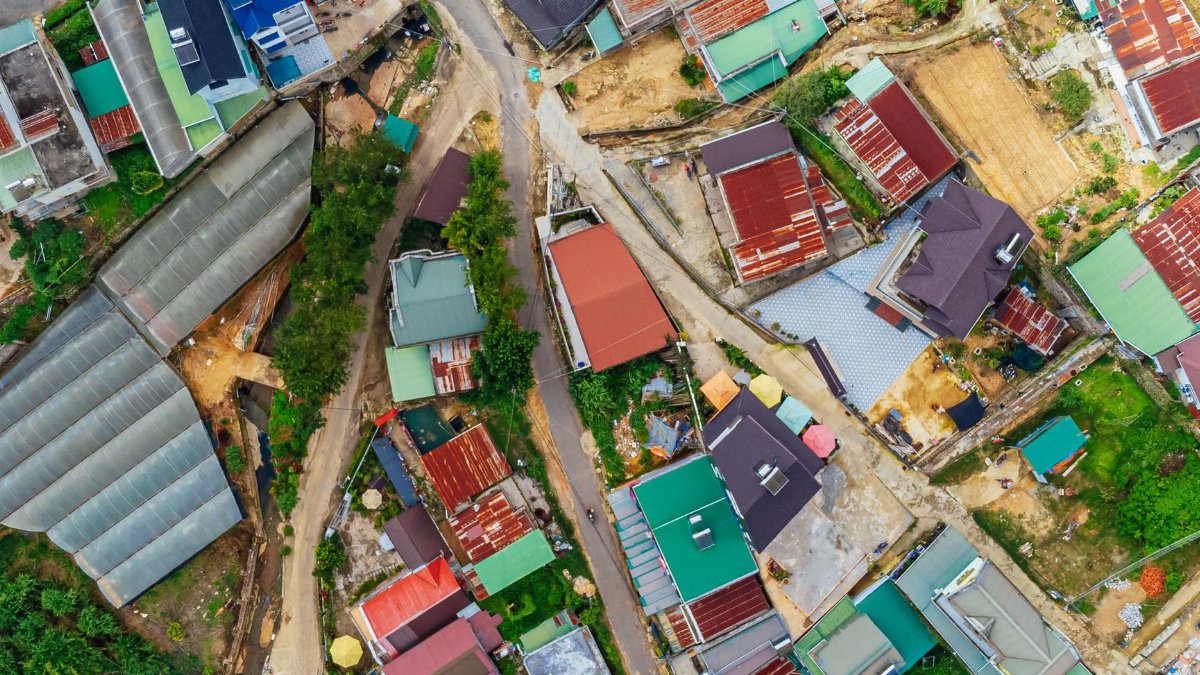 A vibrant aerial view of urban houses with mixed styles and colors, showcasing a lively neighborhood.