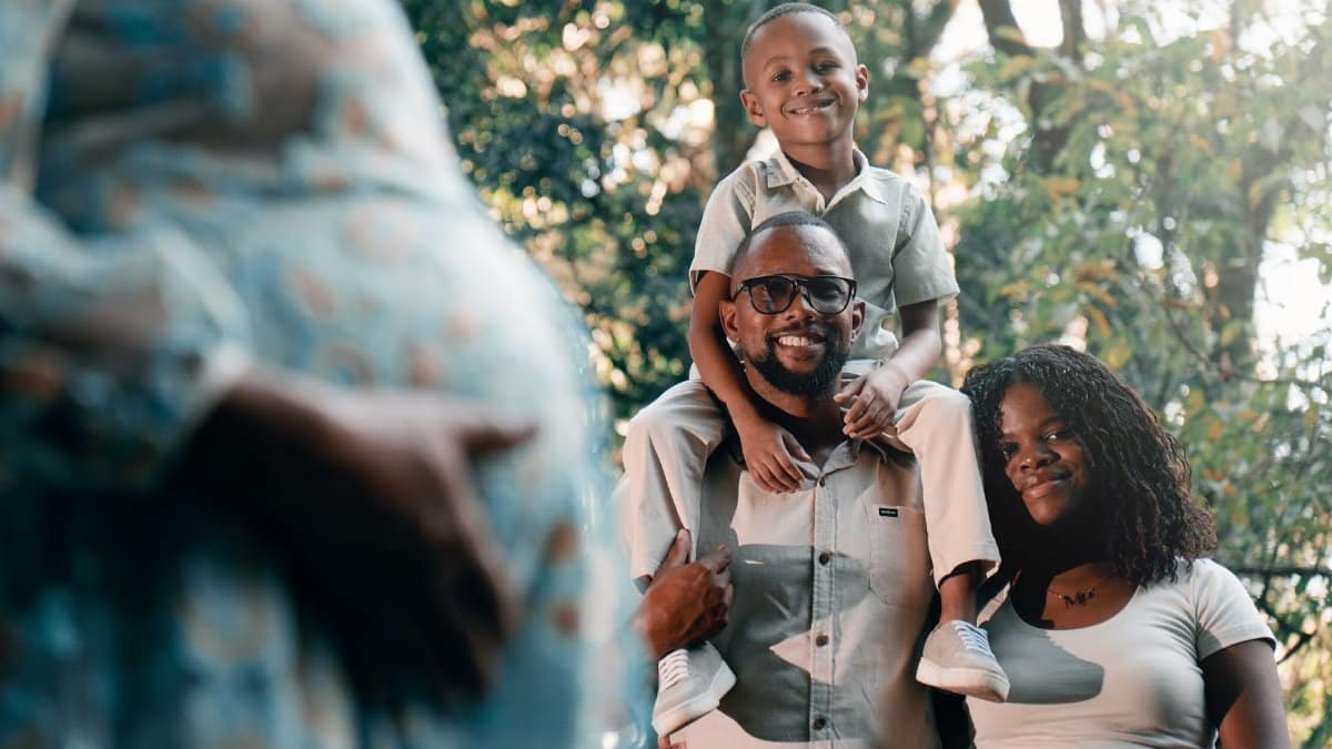 Joyful family spending quality time outdoors with pregnant mother.