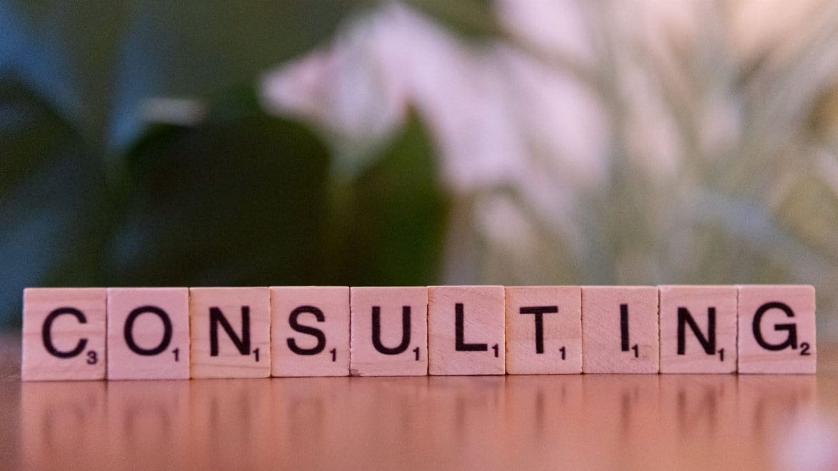 Wooden letter tiles spelling 'Consulting' with a blurred background. Ideal for business concepts.