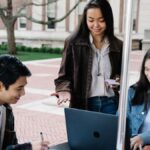 Group of university students collaborating and studying together in an outdoor setting.